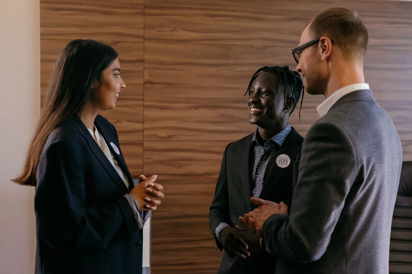 Trois personnes en conversation devant un stand de forum emploi